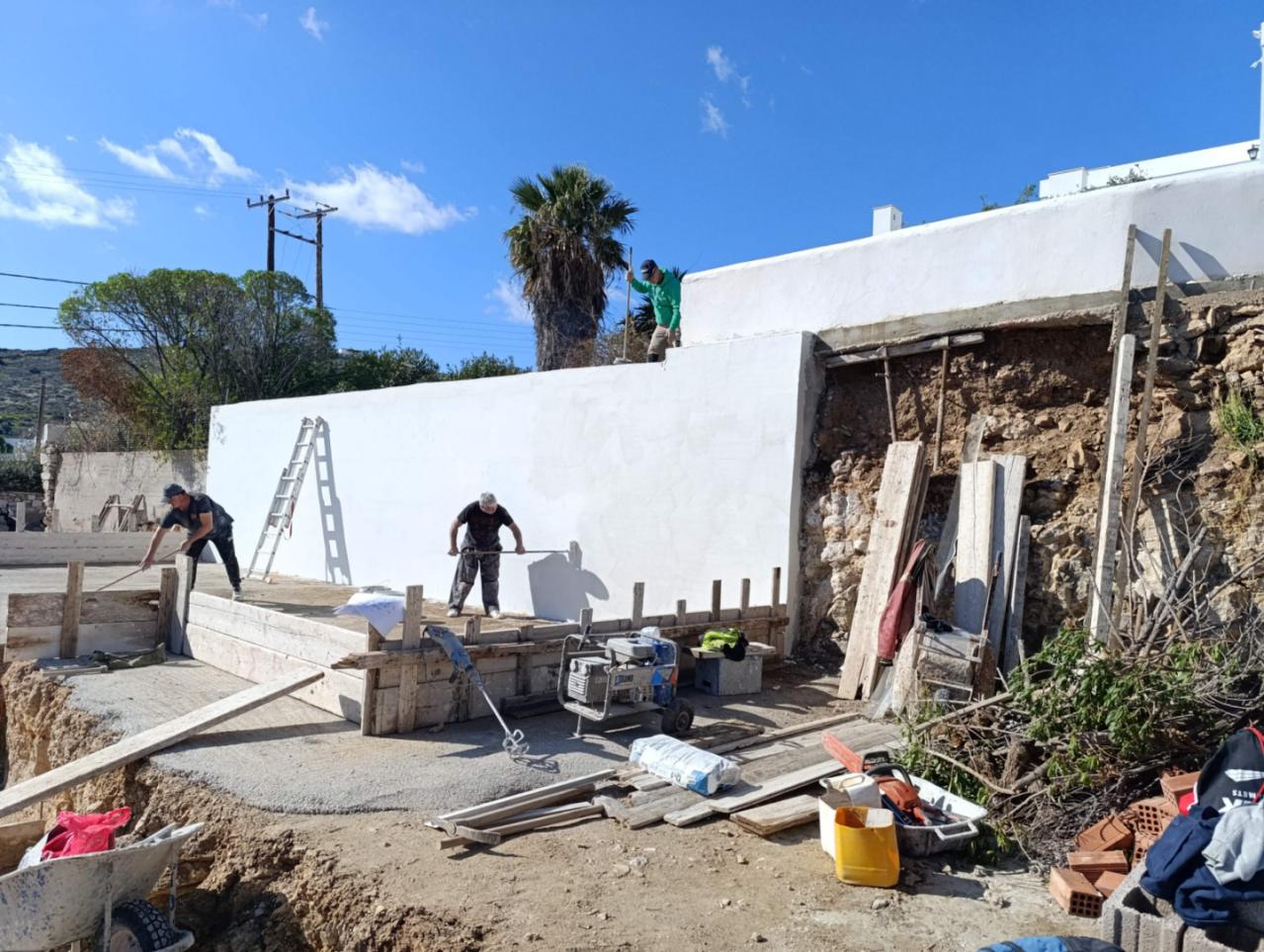 Craftsmen working on the foundations of Navium Suites in Azolimnos, Syros, Spring 2026.